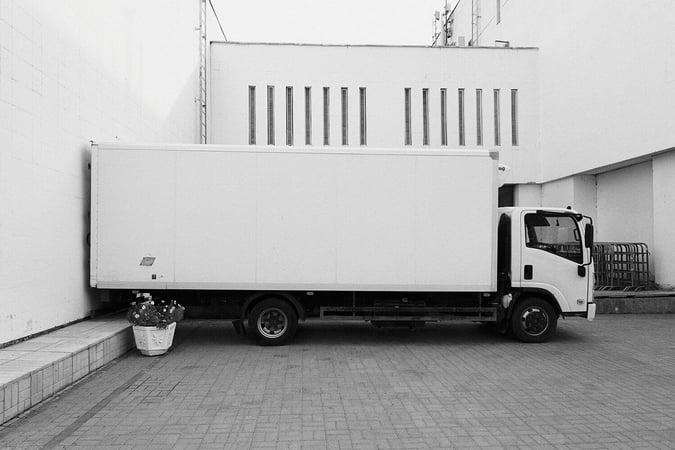 Image en noir et blanc d'un camion garé dans une cour