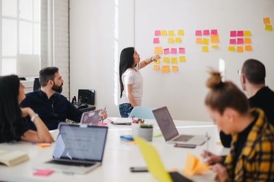 Femme qui intervient lors d'une formation au sein d'une entreprise