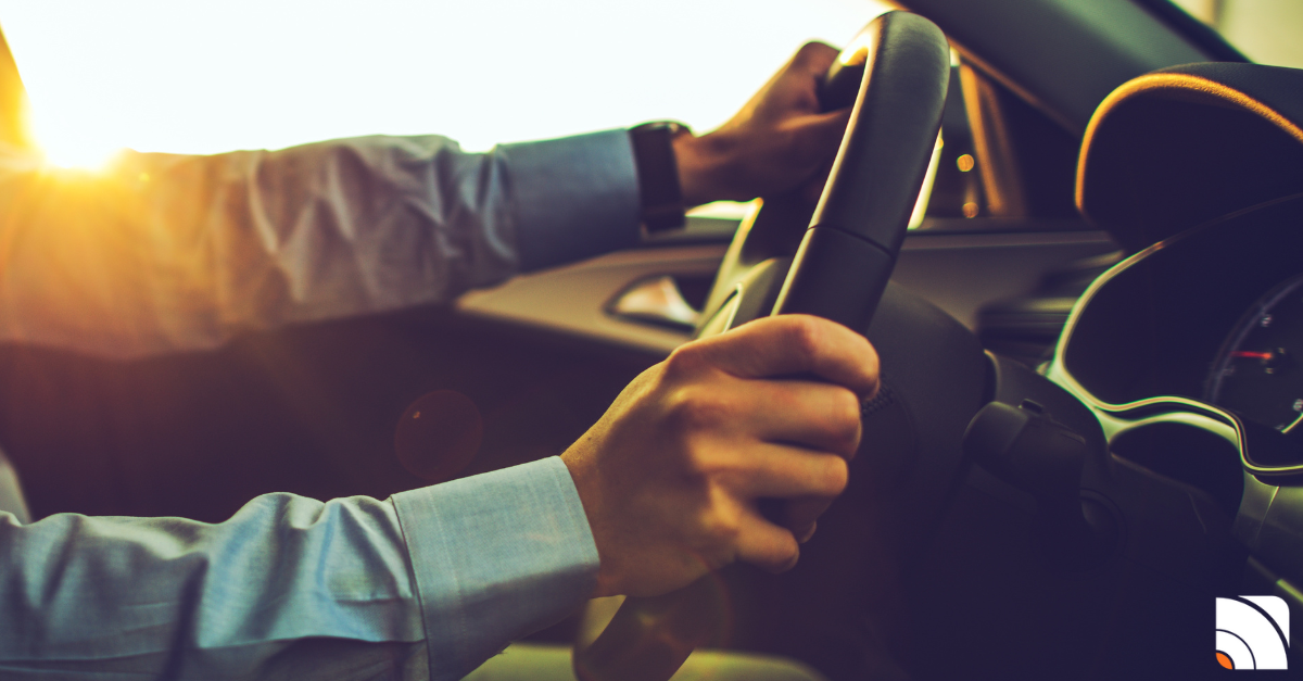 Mains d'une personne sur le volant de sa voiture