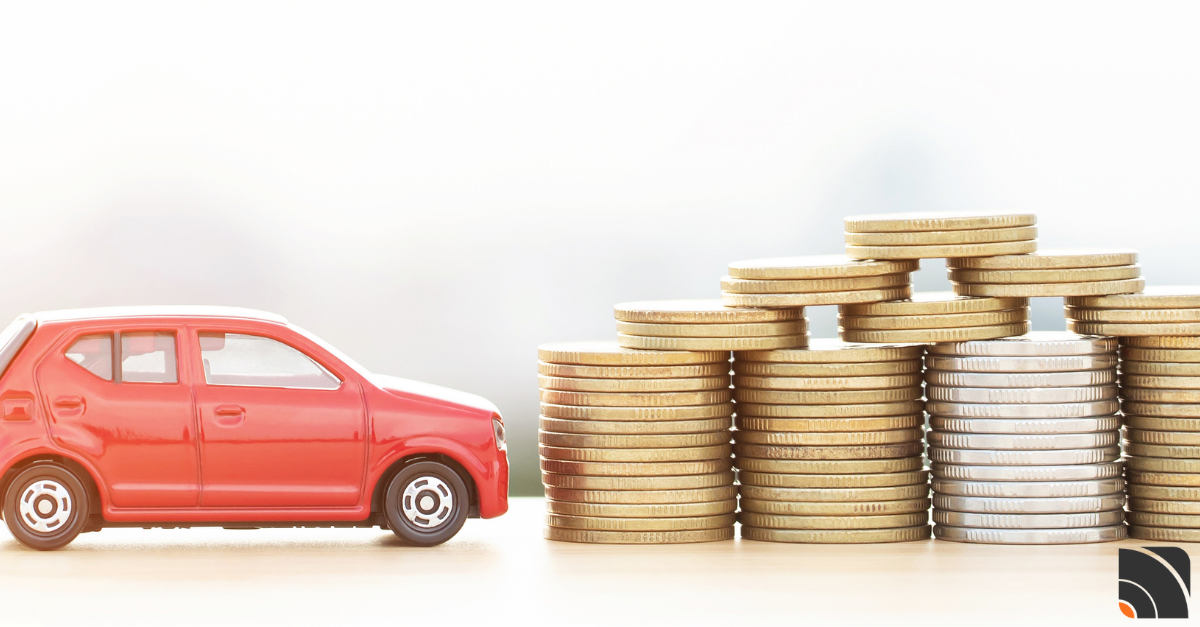 Voiture miniature rouge à côté d'une pile de pièces de monnaie